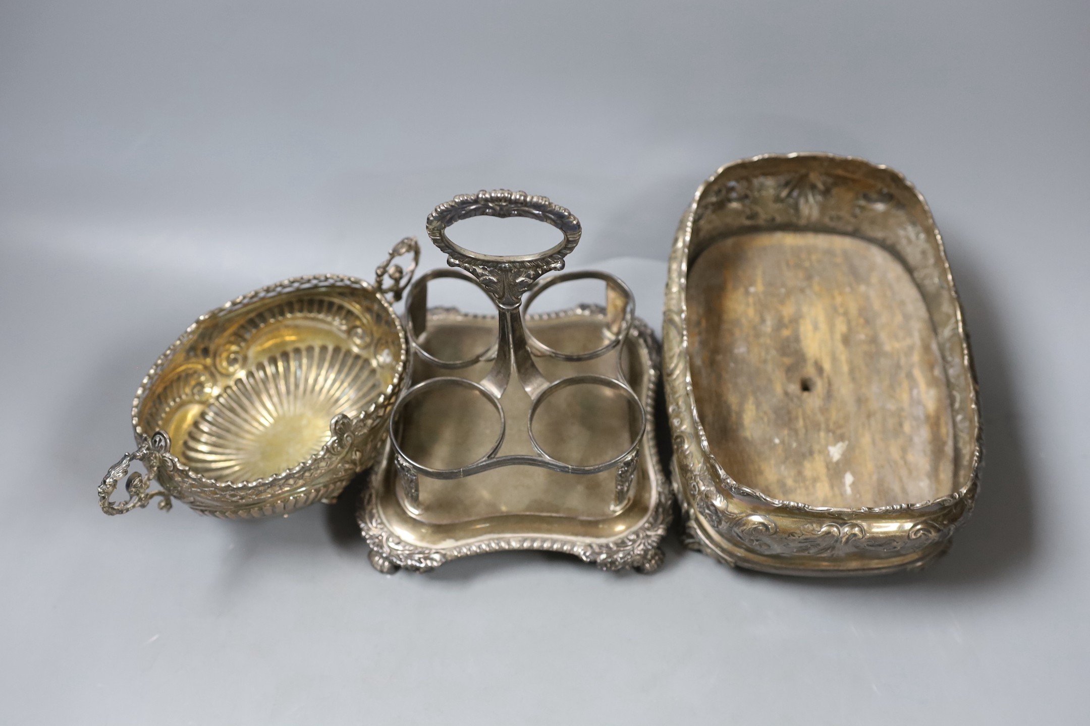 A George III silver cruet stand, no bottles, London, 1816, a late Victorian embossed oval silver basket, London, 1890 and an embossed oval silver cruet stand, no handle or bottles.